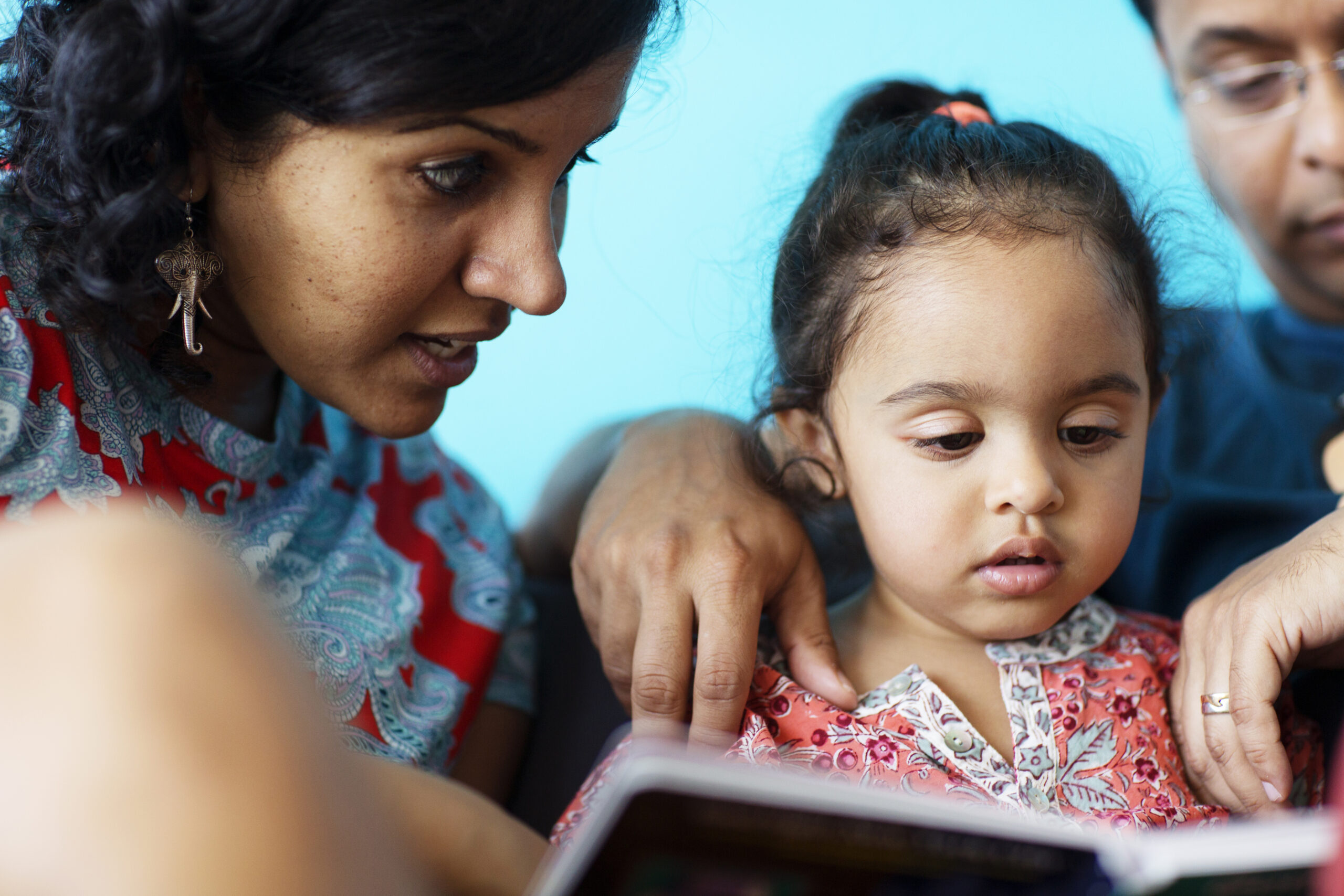 Parents Teaching Daughter At Home